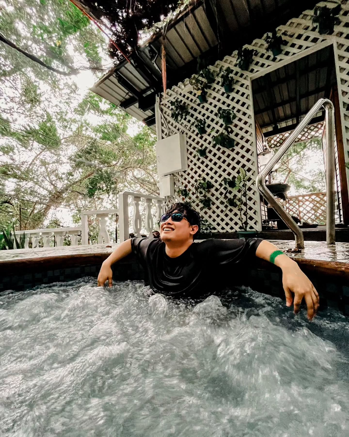 a person with shades relaxing at the jacuzzi pool and smiling